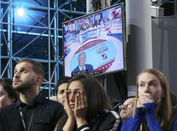 Supporters of Democratic presidential nominee Hillary Clinton watch and wait, with a Donald Trump image on a screen at rear, at her election night rally in New York, U.S., November 8, 2016. REUTERS/Carlos Barria